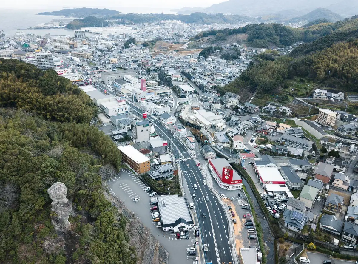 山の斜面に沿って広がる町と幹線道路の空撮